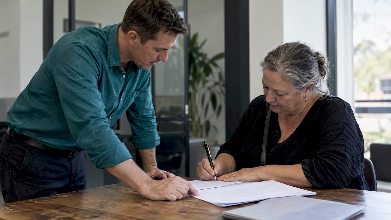 Agent and vendor signing a property listing agreement