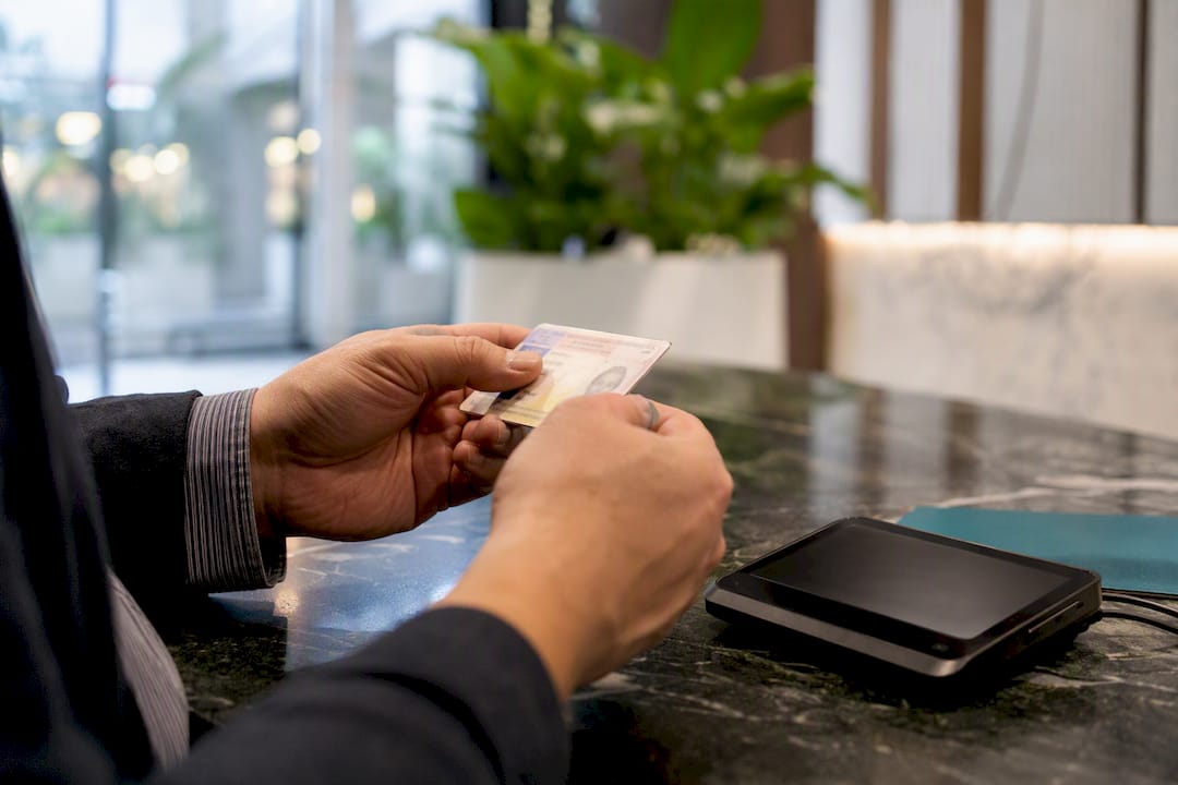 Hands holding ID near verification device
