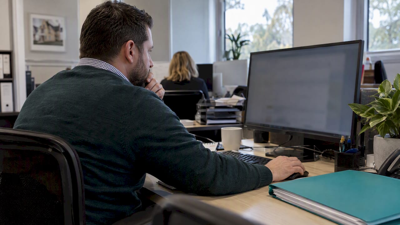 Compliance officer reviewing a real estate customer file